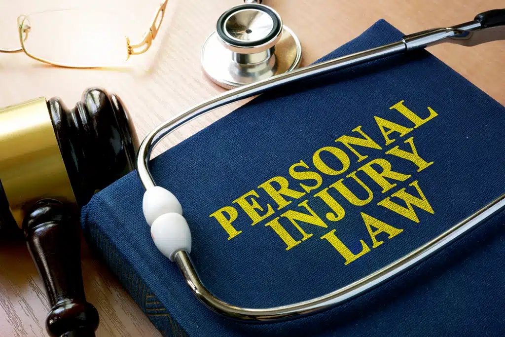 Personal Injury Law book next to a gavel and a stethoscope