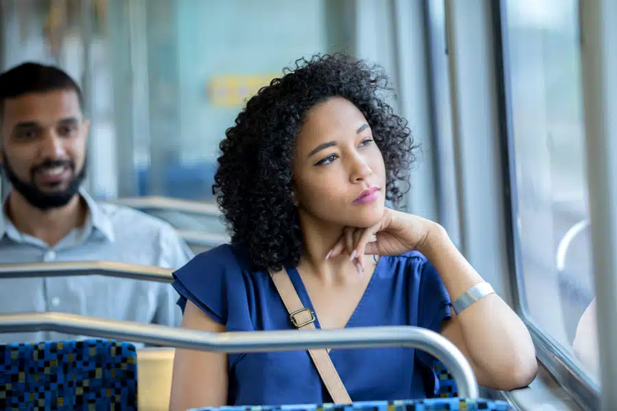 Woman staring out the window on her bus ride.