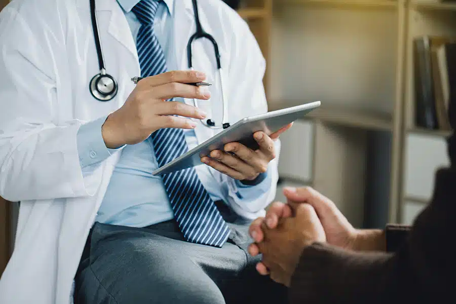 Un médico habla con una paciente sobre su lesión.